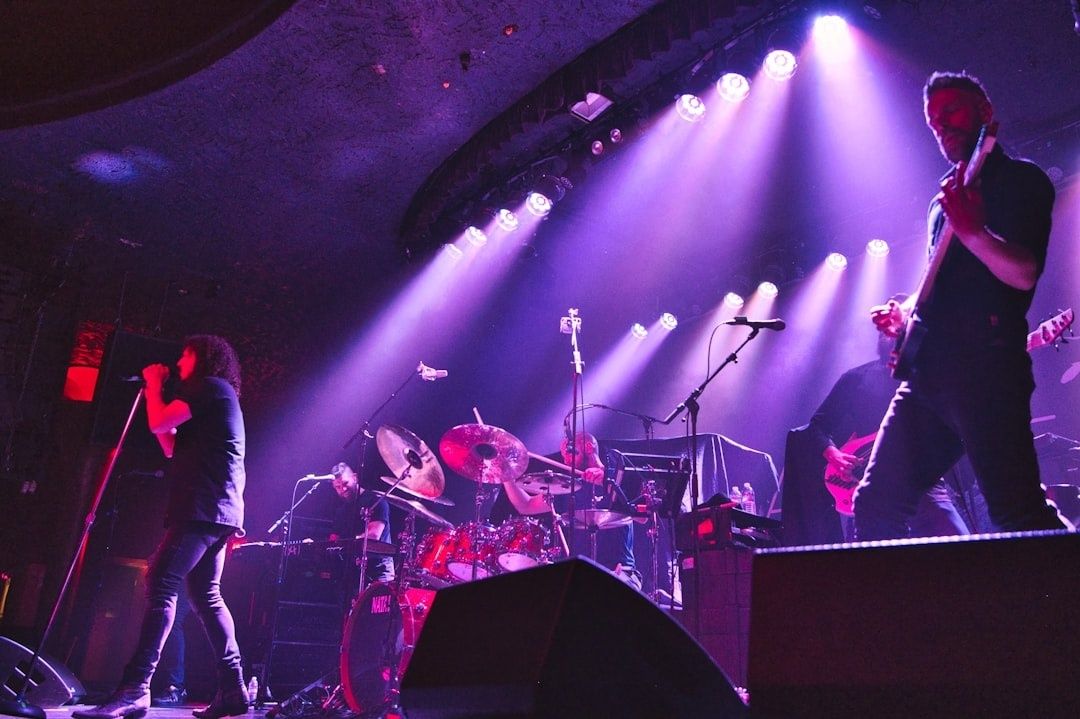 Rockband spielt bei einem Konzert unter violettem Bühnenlicht